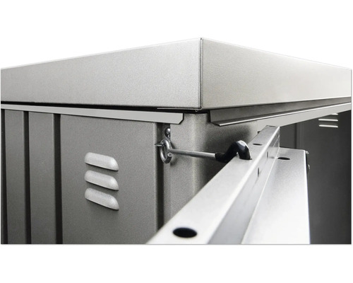 Detailansicht eines Gerätehauses mit Metallelementen, Lüftungsschlitzen und Verriegelungsmechanismus.