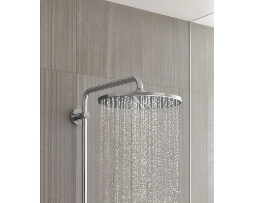 Aufputz-Duschkopf mit Wasserstrahl vor Wandfliesen