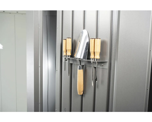 Gartengeräte und Schraubendreher an einer Werkzeugwand.