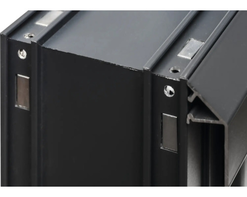 Detailansicht eines schwarzen Aluminiumprofils mit Bohrungen und Magneten