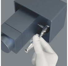 Eine Hand benutzt eine Knarre mit Bit zum Schrauben.