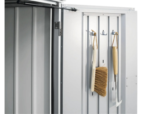 Detailansicht einer Gerätehaustür mit Gartengeräten an Haken