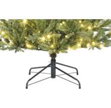 Detailaufnahme eines künstlichen Weihnachtsbaums mit Beleuchtung und Baumständer
