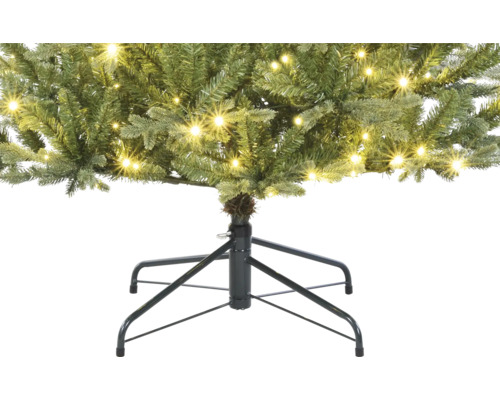 Detailaufnahme eines künstlichen Weihnachtsbaums mit Beleuchtung und Baumständer