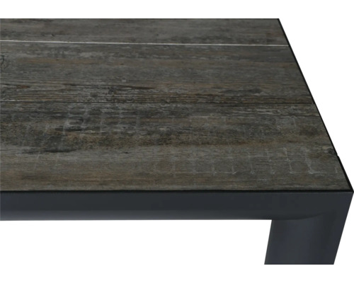 Detailansicht einer Tischplatte mit Holzdekor und Metallrahmen