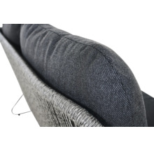 Detailansicht eines Kissens auf einem geflochtenen Sofa