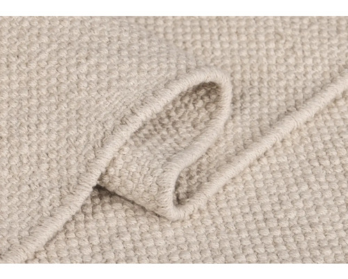 Detailansicht eines hellen Teppichs mit gewebter Textur