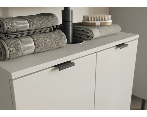 Waschbeckenunterschrank mit Handtüchern und Bürste im Badezimmer