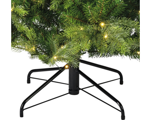 Detailansicht eines künstlichen Weihnachtsbaums mit Beleuchtung und schwarzem Metallständer