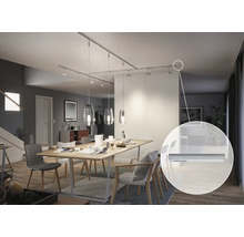 Esszimmer mit Esstisch und Deckenschiene mit Spots und Pendelleuchten.