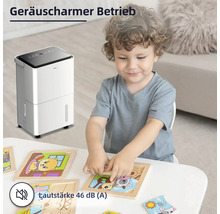 Szene mit einem Jungen, der an einem Tisch mit einem Puzzlespiel sitzt, und einem Luftentfeuchter im Hintergrund.