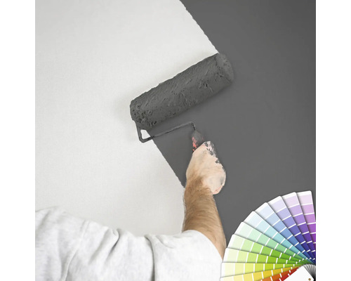 "Eine Person streicht eine Wand mit einer Farbrolle