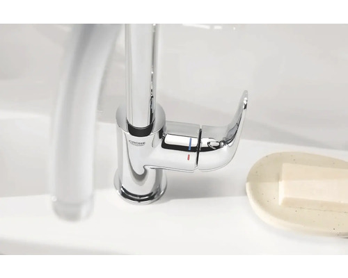 Grohe Logo. Einhebelmischer aus Metall am Waschbecken.