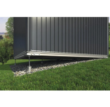 Detailansicht eines Gartenhauses mit Fundament auf einem Rasenhang.