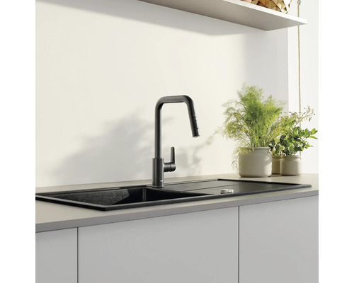 Schwarze Küchenspüle mit Armatur in moderner Küche.
