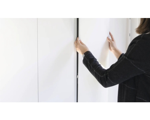 Frau schliesst einen Schrank mit schwarzen Kanten.