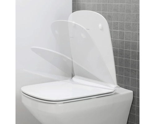 Weisse Toilette mit offenem Toilettendeckel vor grauer Wand