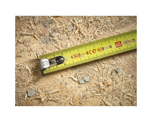 Gelbes Rollbandmass auf einer Holzoberfläche mit Sägespänen