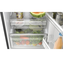 Innenansicht eines Kühlschranks mit Gemüsefächern und verschiedenen Lebensmitteln wie Gemüse und Obst