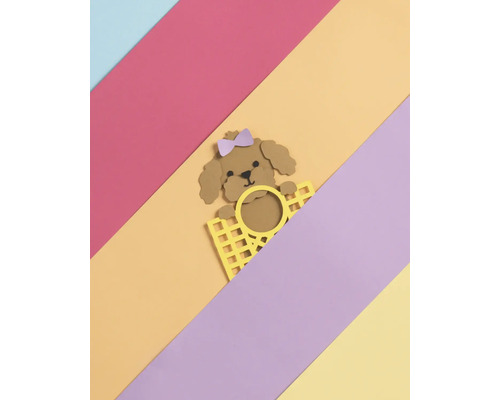 Dekorative Papierbastelarbeit eines Pudels mit Schleife hinter einem Gitter