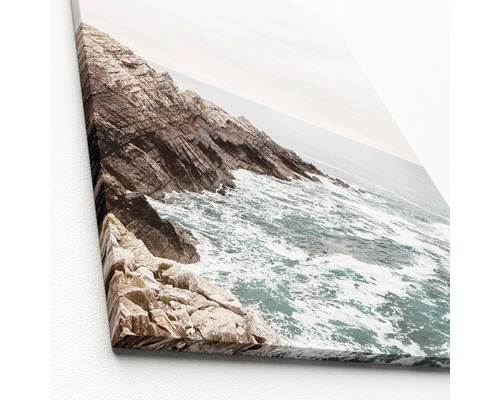 Nahaufnahme einer Leinwand mit einem Felsenstrand und Meer