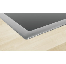 Detailansicht eines Kochfelds aus Glaskeramik mit Edelstahlrahmen