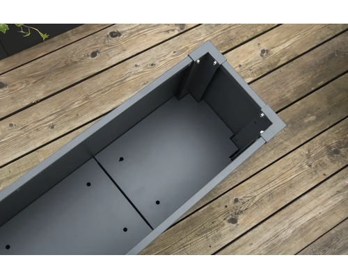 Leere, längliche, graue Pflanzkiste auf einem Holzboden