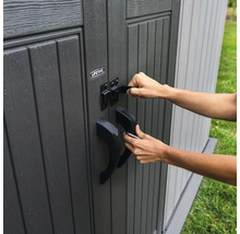 Person verschließt eine Gartengerät-Aufbewahrungsbox mit einem Riegel