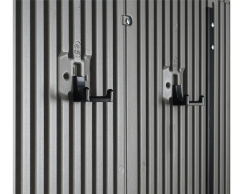 Zwei schwarze Gerätehalter an einer grau gerillten Wand