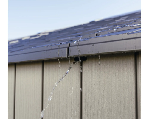 Wasser fließt vom Dach eines Gartenhauses.