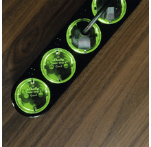 Schwarze Shelly Power Strip 4 Mehrfachsteckdose mit vier Steckplätzen auf einem Holztisch