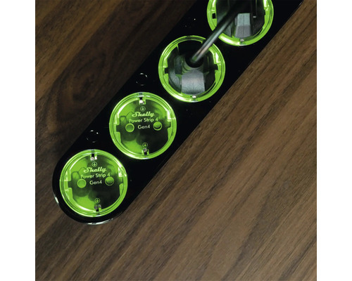 Schwarze Shelly Power Strip 4 Mehrfachsteckdose mit vier Steckplätzen auf einem Holztisch