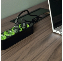 Mehrfachsteckdose mit eingesteckten Geräten auf einem Tisch