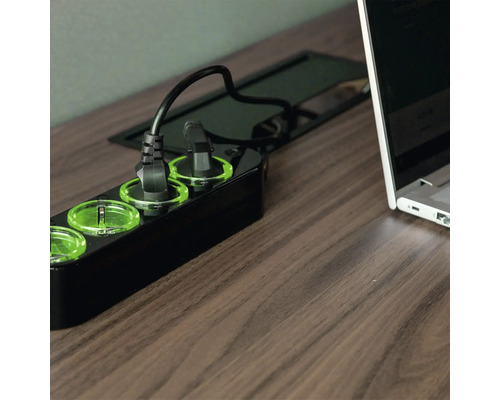 Mehrfachsteckdose mit eingesteckten Geräten auf einem Tisch