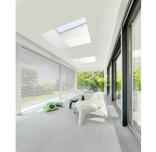 Heller Raum mit Dachfenstern, Jalousien und Schiebetüren für viel Tageslicht