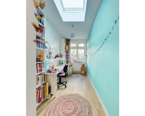 Heller, organisierter Raum mit Bücherregal, Schreibtisch und rundem Teppich