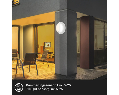 Leuchtende Außenwandleuchte mit Dämmerungssensor an einer Gebäudefassade