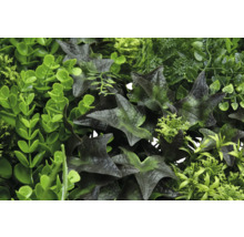 Künstliche Pflanzenwand mit verschiedenen Grüntönen und Blattstrukturen.