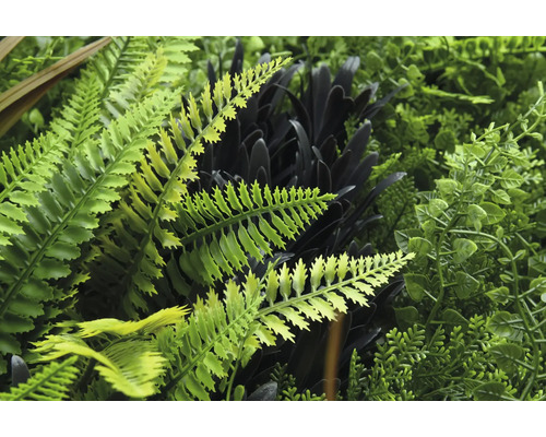 Detailansicht einer künstlichen Pflanzenwand mit verschiedenen Farnen und Blättern.