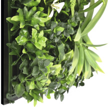 Künstliche Pflanzenwand mit verschiedenen grünen Blättern und einer weißen Blüte