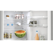 Innenansicht eines Kühlschranks mit Lebensmitteln wie Wassermelone, Getränken und Desserts