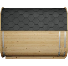 Seitenansicht einer Fasssauna aus hellem Holz mit schwarzen Bitumenschindeln in Wabenform und Spannbändern aus Metall.