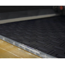 Schwarze Antirutschmatte mit Riffelblechmuster im Laderaum eines Fahrzeugs.