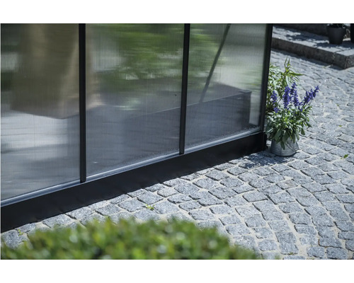 Detailansicht eines Gewächshauses mit Polycarbonatplatten und Pflanze im Topf