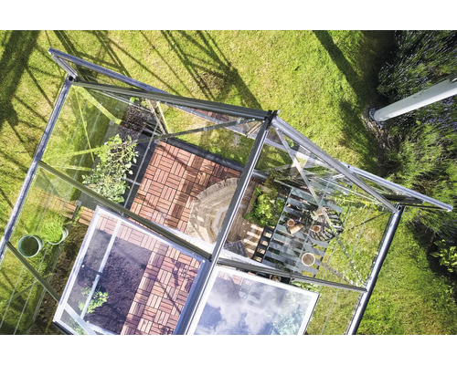 Ansicht von oben eines Gewächshauses mit Pflanzen und Zubehör im Garten