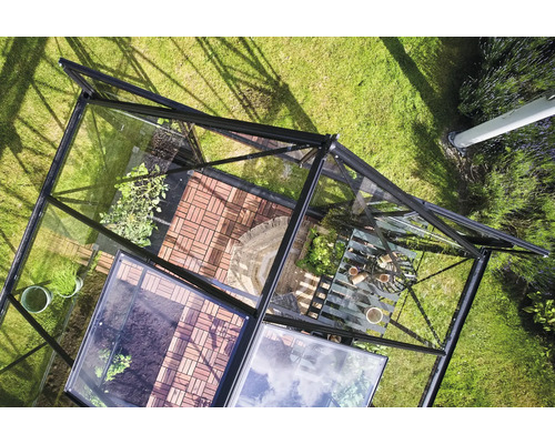 Ansicht von oben auf ein Gewächshaus mit Pflanzen und Gartengeräten