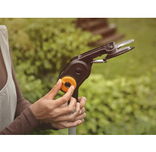 Bedienung einer Strauchschere mit Stiel im Garten