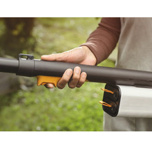 Eine Person hält einen Laubbläser in der Hand.