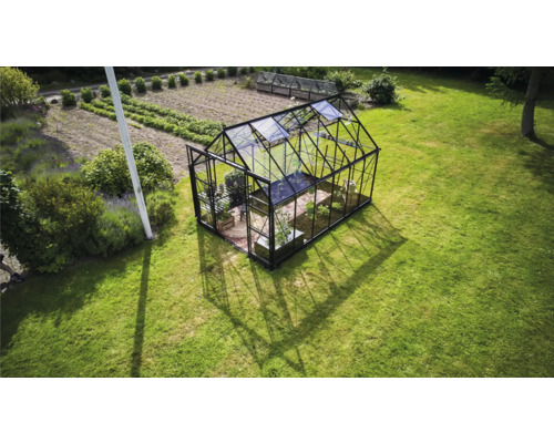 Gewächshaus auf einer Rasenfläche im Garten