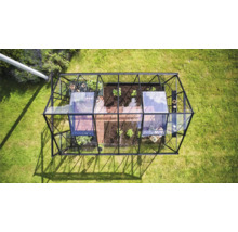 Draufsicht eines Gewächshauses aus Glas und Metall im Garten.